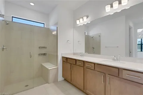 a bathroom with a double vanity sink mirror and shower