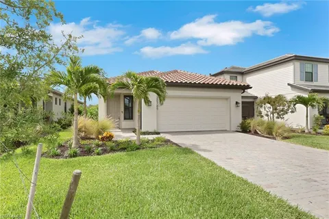 a front view of a house with a garden and yard