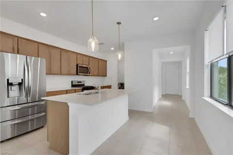 a kitchen with a refrigerator a sink and a stove top oven with wooden floor