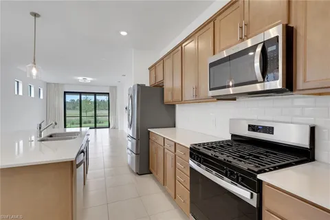 a kitchen with stainless steel appliances a stove microwave sink and refrigerator