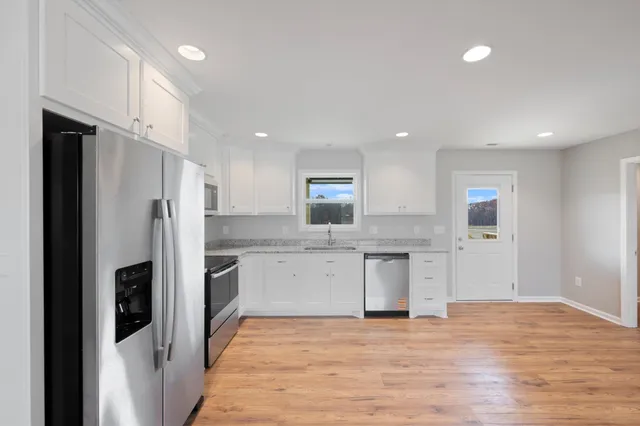 a kitchen with stainless steel appliances granite countertop a refrigerator and a stove top oven