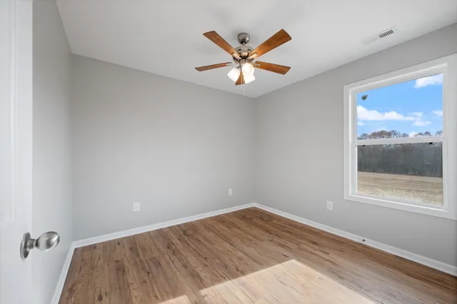 wooden floor in an empty room with a window