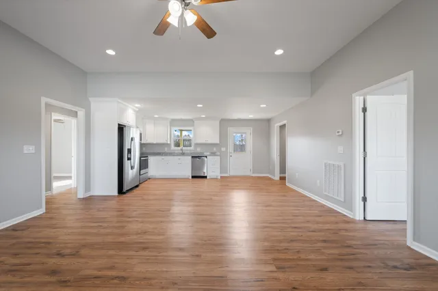 a view of an empty room with wooden floor
