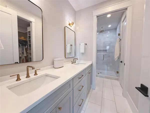a bathroom with a shower tub double vanity sink and mirror