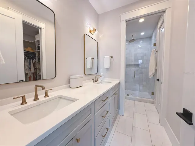 a bathroom with a shower tub double vanity sink and mirror