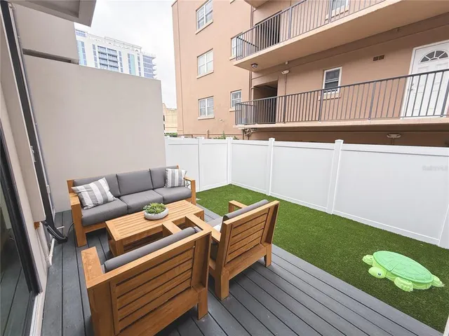 a view of a roof deck with couches and wooden floor
