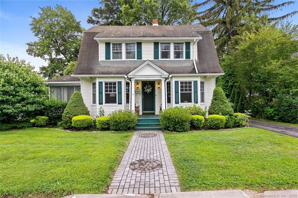 a front view of a house with garden and yard