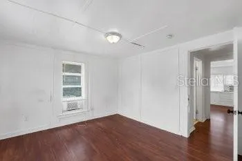 wooden floor in an empty room with a window