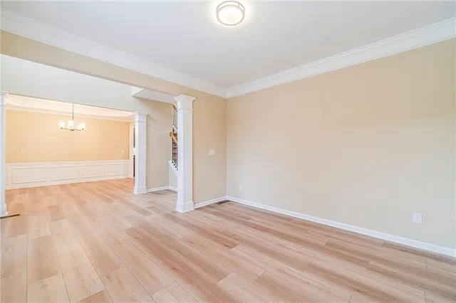 an empty room with wooden floor and cabinet