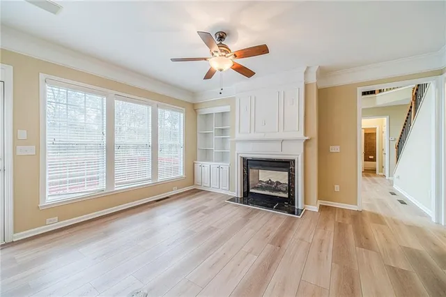 a kitchen with stainless steel appliances kitchen island granite countertop a refrigerator a sink dishwasher a stove with wooden cabinets and floor