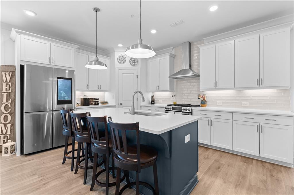 300 Olmstead Way Alpharetta, GA 30022 - Photo 12 of 52 a kitchen with kitchen island granite countertop a sink a center island and cabinets