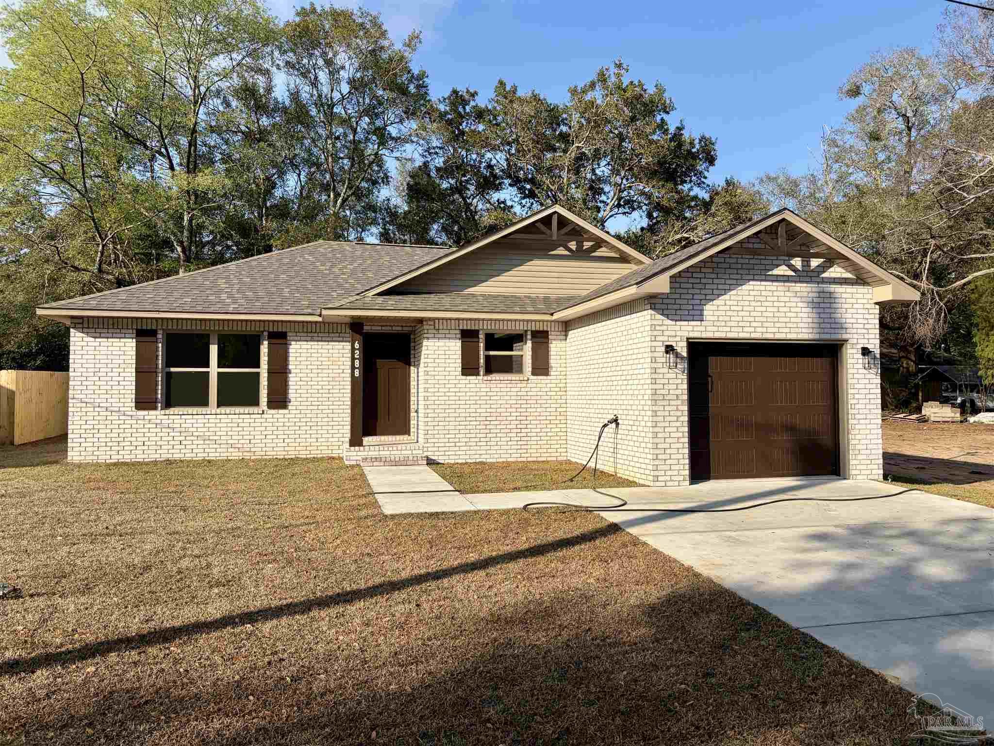 a front view of a house with a garden and yard