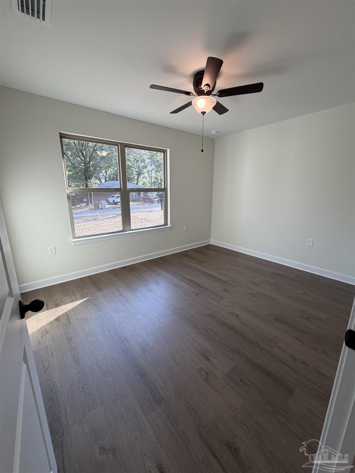 6288 Long Street Milton, FL 32570 - Photo 11 of 16 an empty room with wooden floor fan and windows