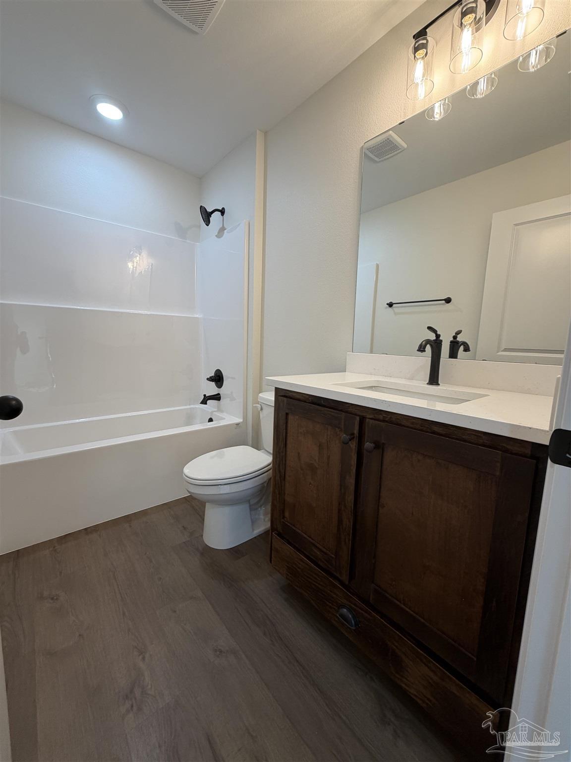 6288 Long Street Milton, FL 32570 - Photo 12 of 16 a bathroom with a sink a toilet and a large mirror