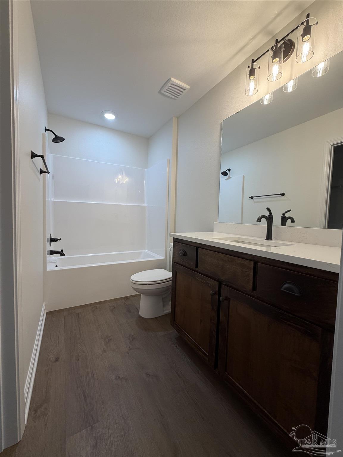6288 Long Street Milton, FL 32570 - Photo 15 of 16 a bathroom with a double vanity sink toilet mirror and bathtub