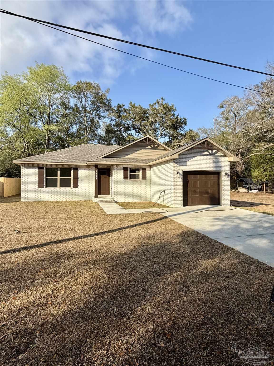 6288 Long Street Milton, FL 32570 - Photo 2 of 16 a front view of a house with a yard and garage