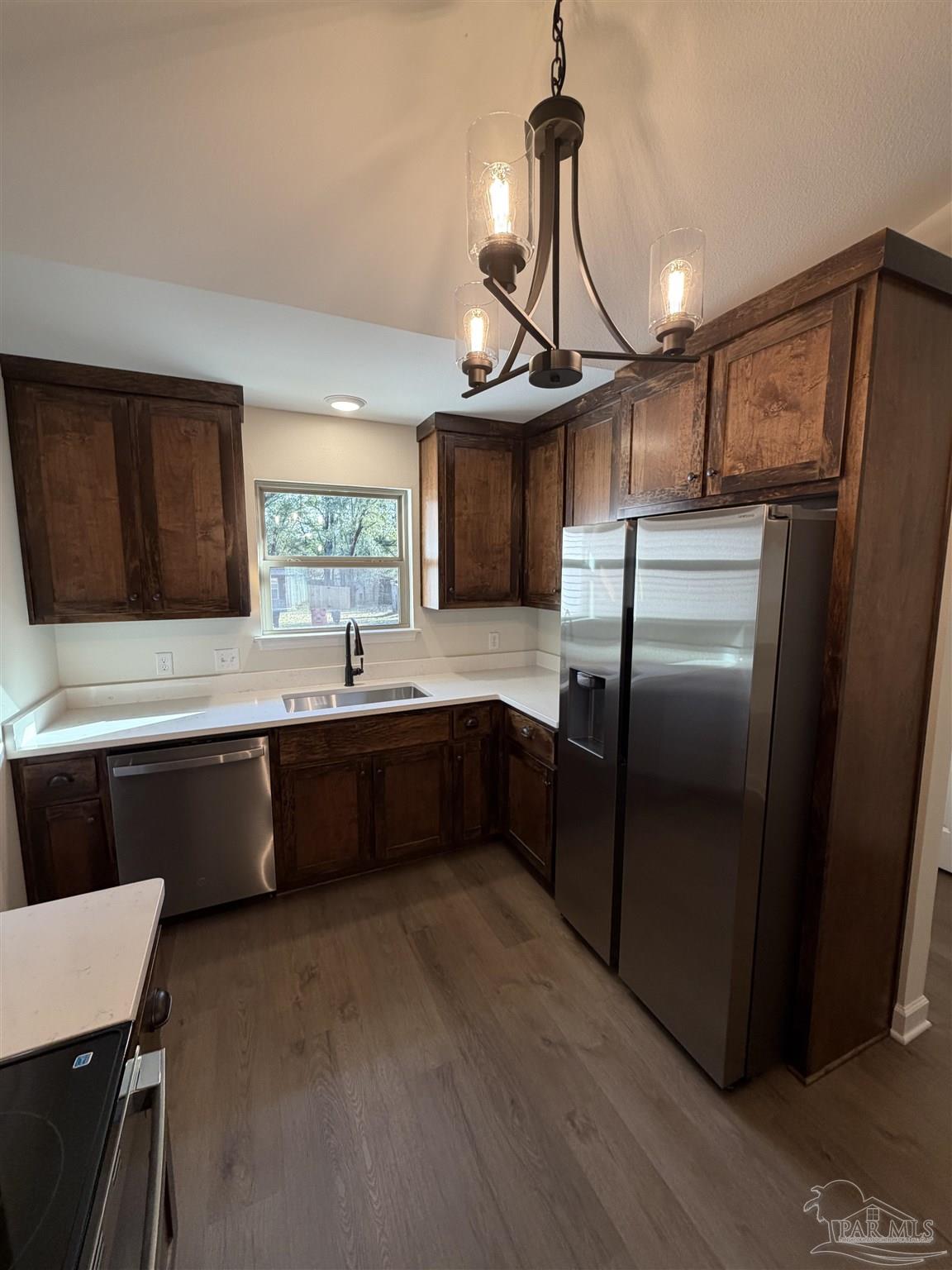 6288 Long Street Milton, FL 32570 - Photo 5 of 16 a kitchen with stainless steel appliances granite countertop a refrigerator a sink dishwasher a stove with wooden cabinets