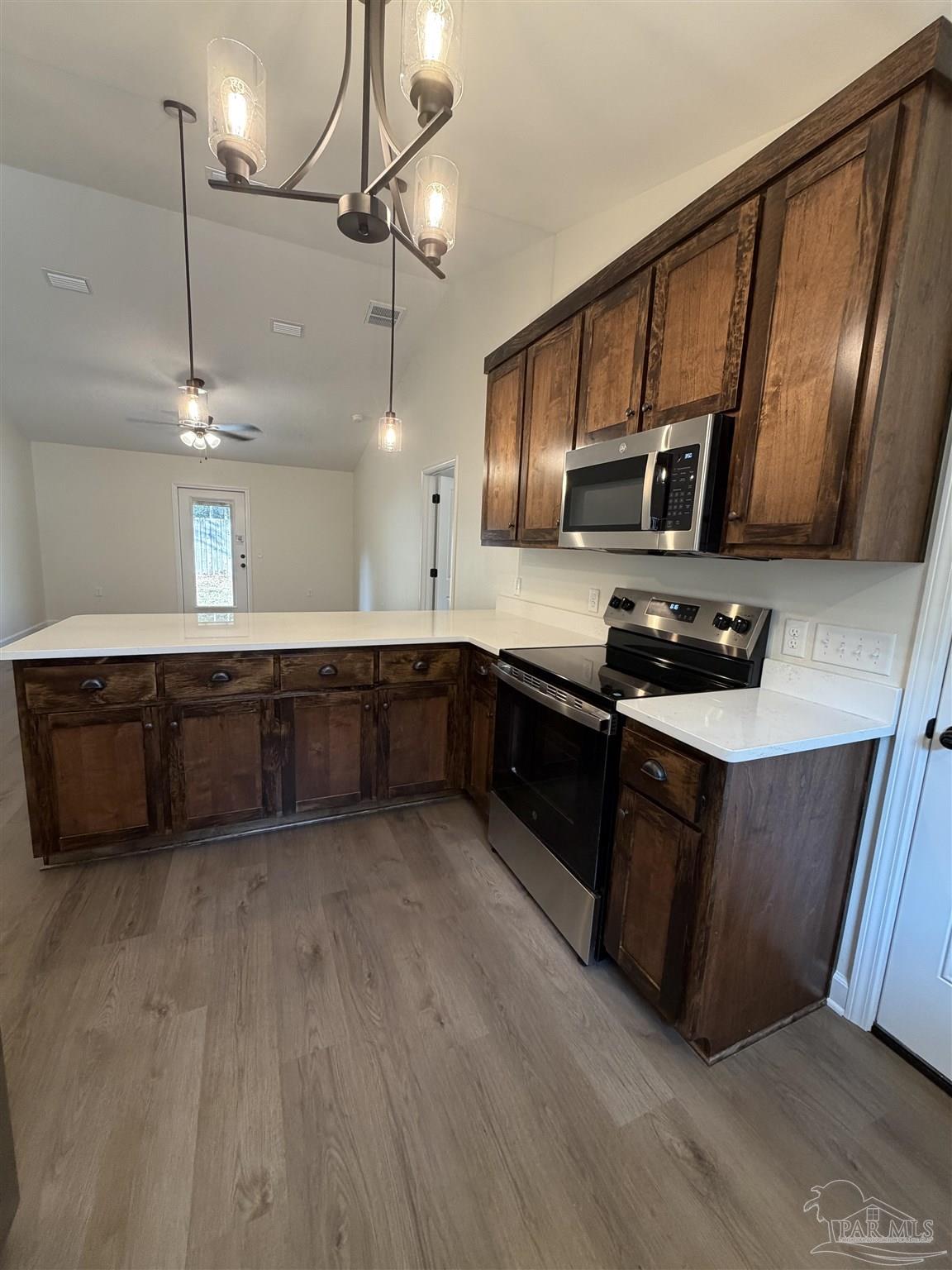 6288 Long Street Milton, FL 32570 - Photo 6 of 16 a kitchen with stainless steel appliances granite countertop a sink a stove and a wooden floors