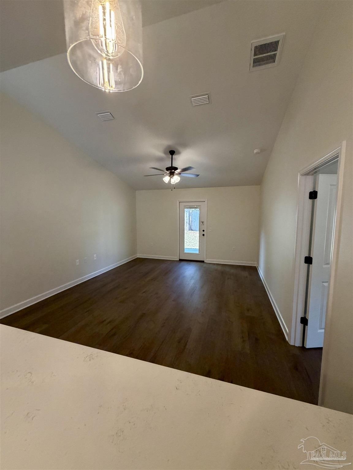 6288 Long Street Milton, FL 32570 - Photo 7 of 16 en empty room with wooden floor chandelier fan and windows