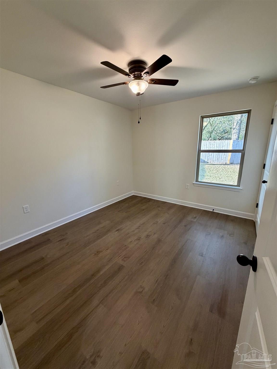 6288 Long Street Milton, FL 32570 - Photo 10 of 16 a view of a room with wooden floor a ceiling fan and windows