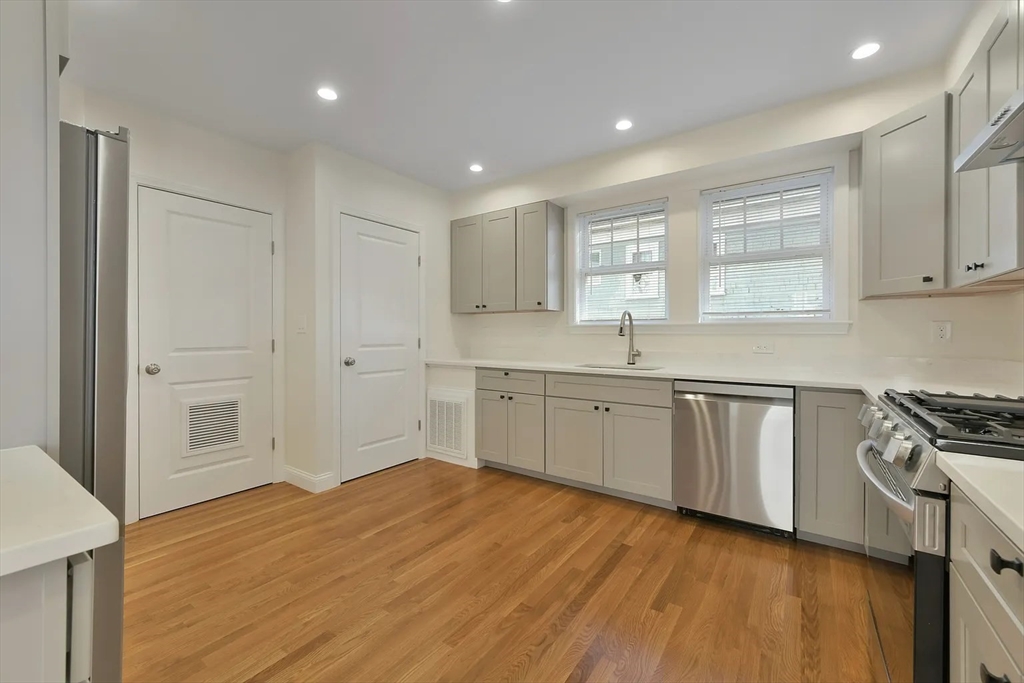 48 Manthorne Road, Unit 1 Boston, MA 02132 - Photo 11 of 17 a kitchen with granite countertop white cabinets and white appliances