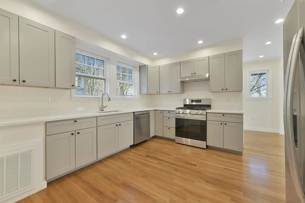 48 Manthorne Road, Unit 1 Boston, MA 02132 - Photo 12 of 17 a kitchen with granite countertop white cabinets and white appliances