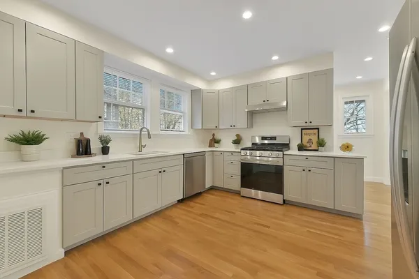 a kitchen with white cabinets stainless steel appliances and sink