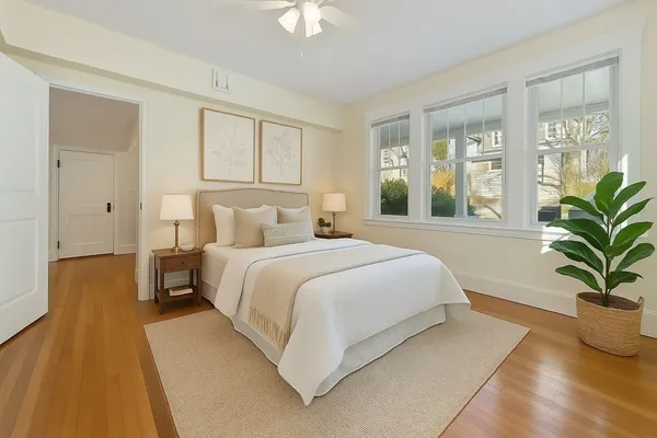 a bedroom with a large bed and a potted plant