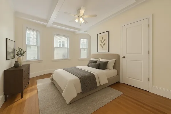 a spacious bedroom with a bed and wooden floor