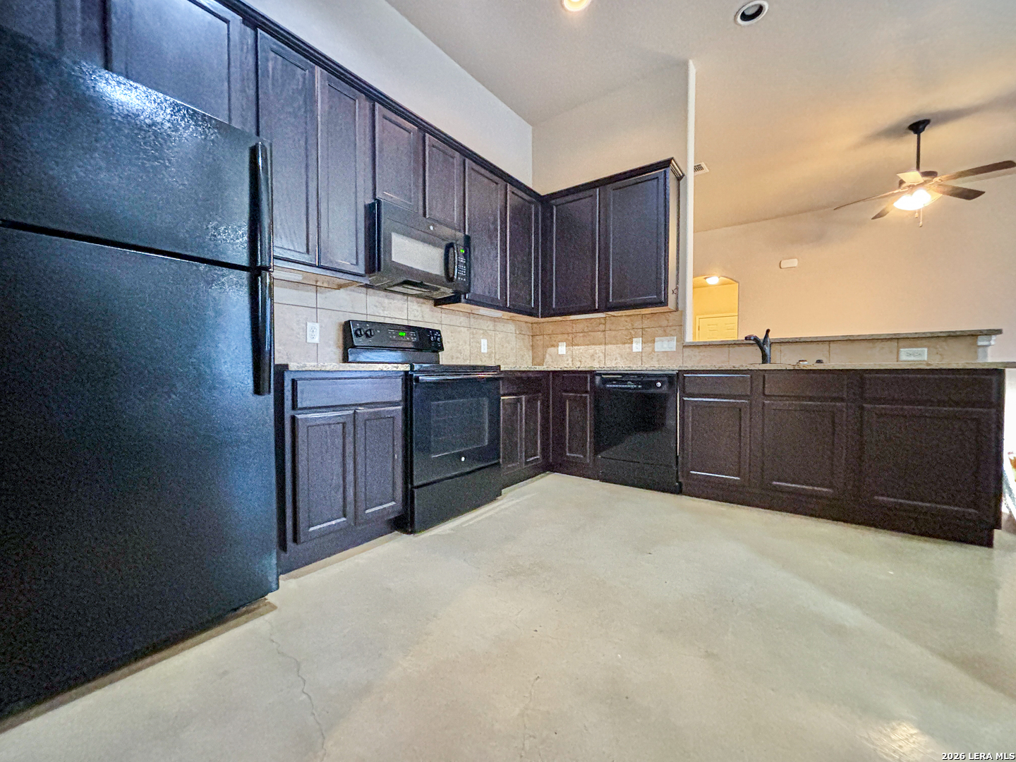 746-748 Saengerhalle Road New Braunfels, TX 78130 - Photo 8 of 14 a kitchen with stainless steel appliances granite countertop a refrigerator a sink dishwasher and wooden cabinets