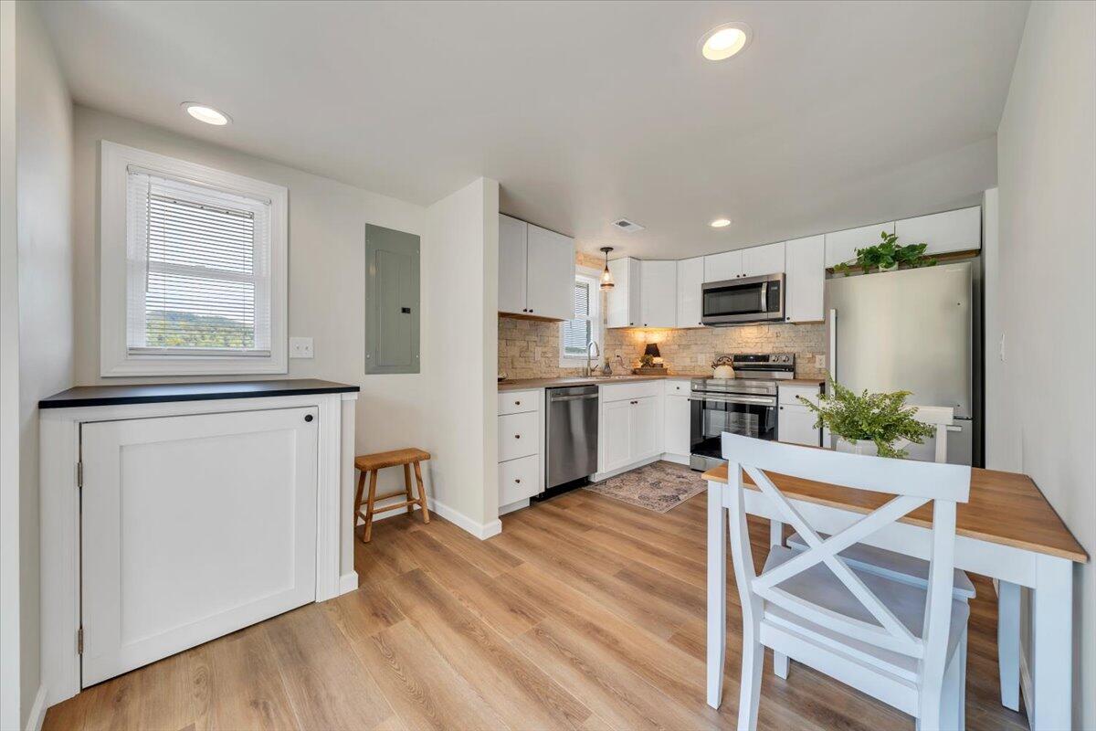 7153 Peppers Ferry Road Max Meadows, VA 24360 - Photo 11 of 67 a kitchen with stainless steel appliances granite countertop a refrigerator a stove a sink dishwasher and white cabinets with wooden floor
