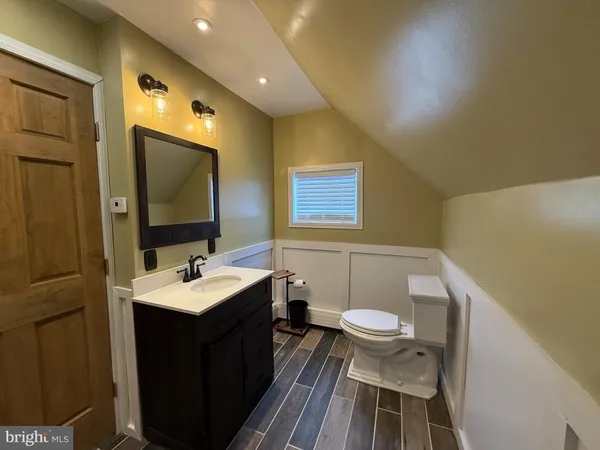 a bathroom with a sink a toilet a mirror and shower