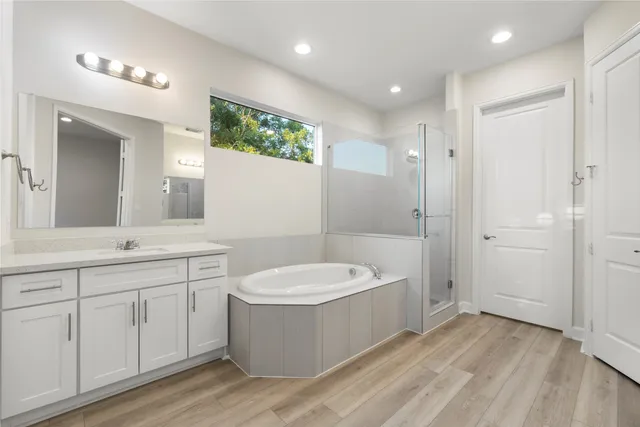 a bathroom with a double vanity sink a mirror and a bathtub