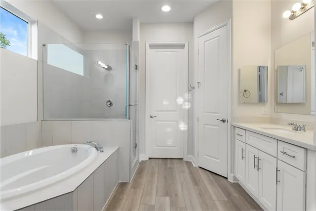 a bathroom with a tub a sink and mirrors