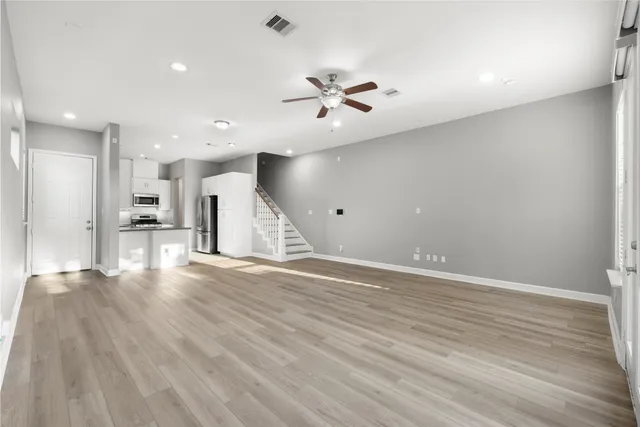 a view of an empty room with wooden floor