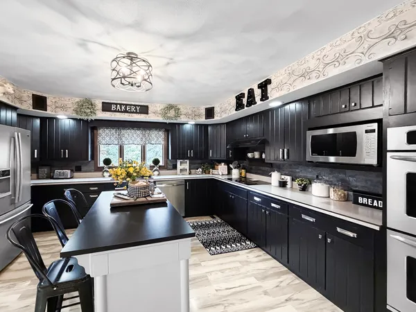 a kitchen with stainless steel appliances granite countertop a sink dishwasher a stove a refrigerator cabinets and chairs