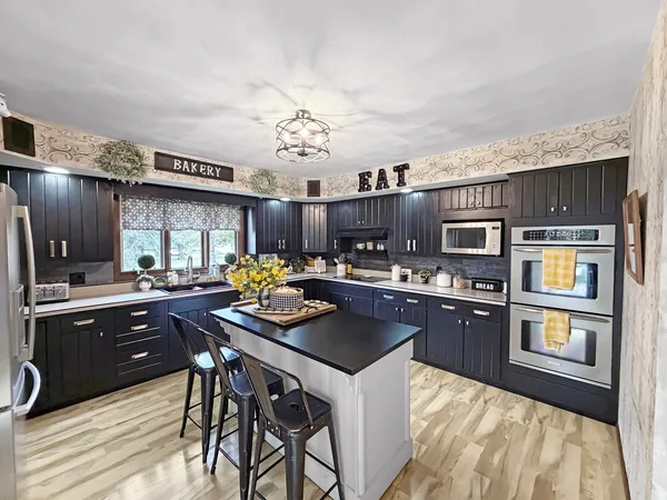 a kitchen with stainless steel appliances kitchen island granite countertop a sink and cabinets