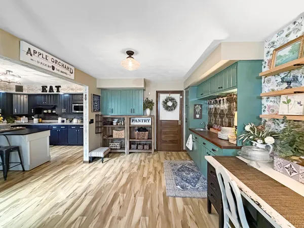a kitchen with stainless steel appliances wooden floor dining table and chairs