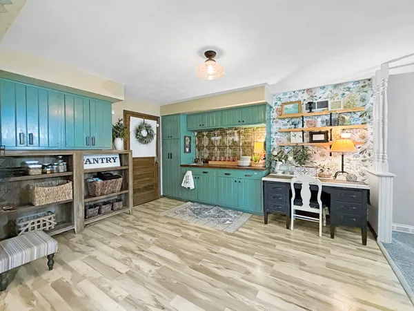 a living room with furniture a flat screen tv and kitchen view