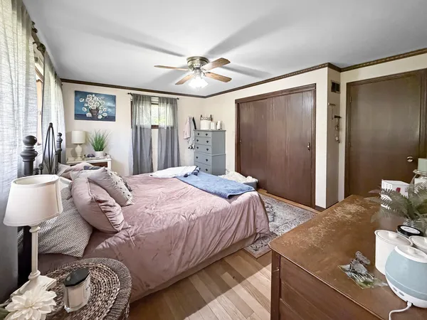 a bedroom with a bed and wooden floor