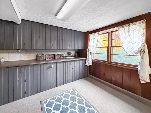 a kitchen with a window a sink and a wooden cabinets