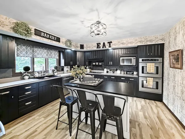 a kitchen with stainless steel appliances granite countertop a sink dishwasher and cabinets with wooden floor