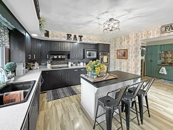 a kitchen with stainless steel appliances kitchen island granite countertop a sink and cabinets