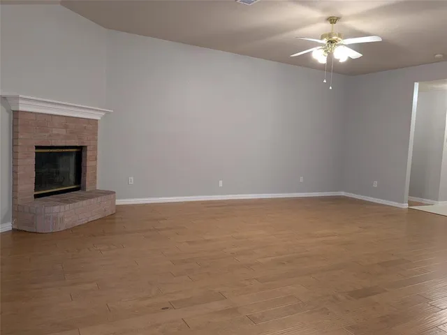 a view of a room with a ceiling fan and a fireplace