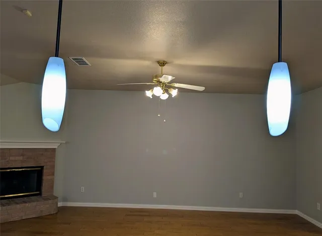a view of a room with wooden floor and chandelier