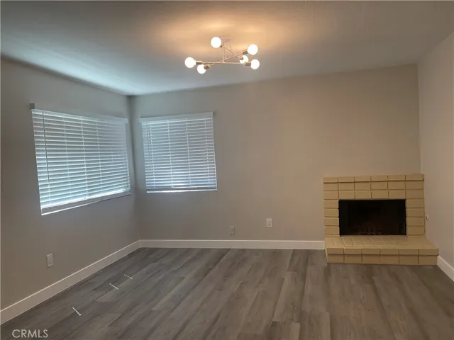 an empty room with windows and fireplace