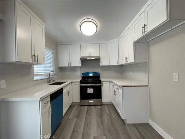 a kitchen with stainless steel appliances granite countertop wooden cabinets and a stove top oven