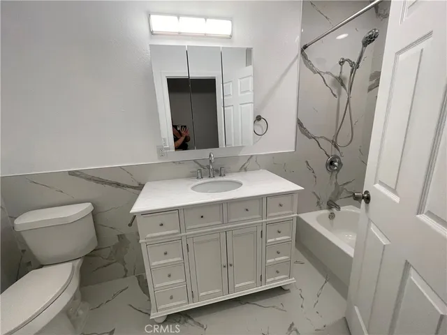 a bathroom with a sink toilet double vanity and tub