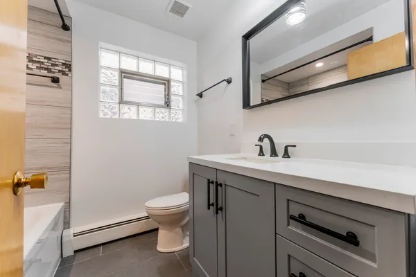 a bathroom with a sink a toilet and a window