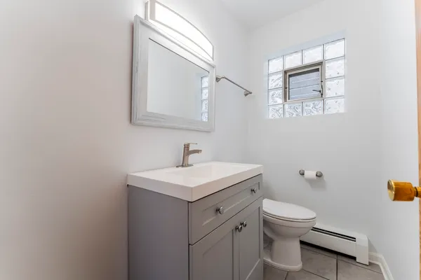 a bathroom with a toilet sink vanity and mirror